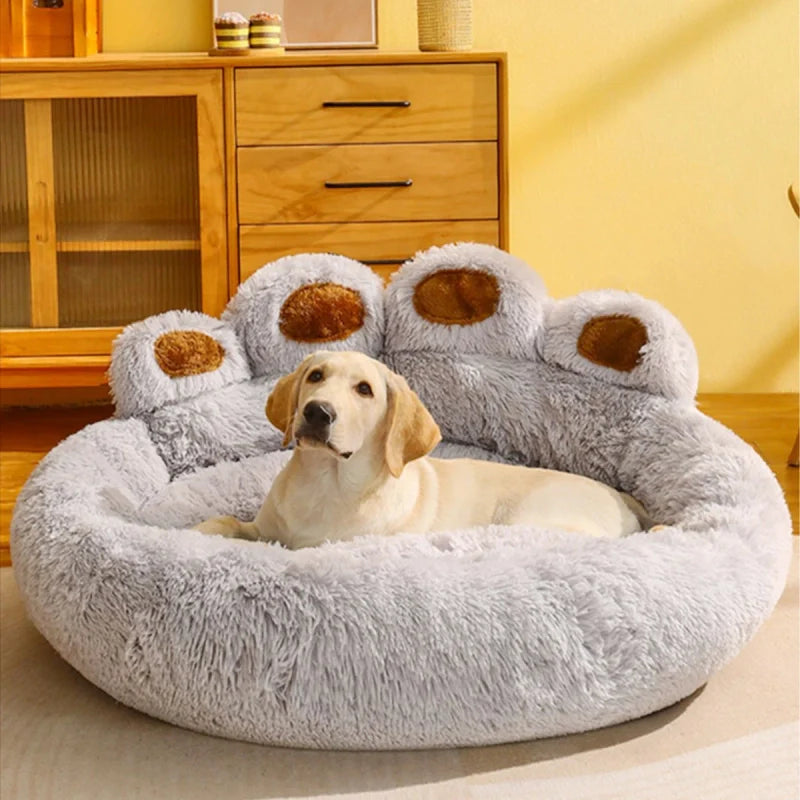 Chien installé dans un lit gris clair en forme de patte