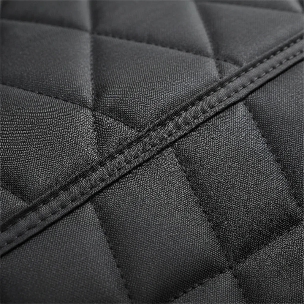 Détail du tissu matelassé noir et des coutures de la housse de siège