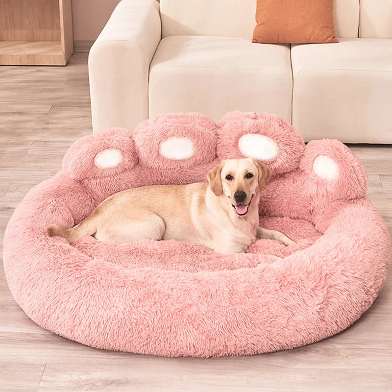 Chien installé dans un lit rose en forme de patte